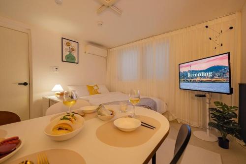 a living room with a table and a tv in a room at Warm Place in Seoul