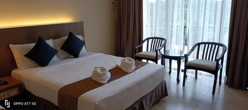 a hotel room with a bed and a table and chairs at Amverton Heritage Resort in Melaka