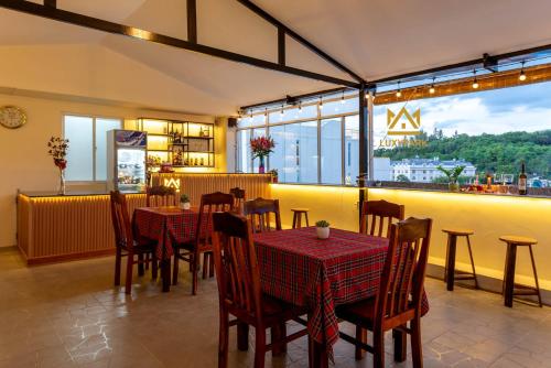 restauracja ze stołami i krzesłami oraz dużym oknem w obiekcie Luxy Park Hotel & Residences - Phu Quoc City Centre w Duong Dong