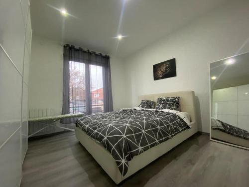 a bedroom with a bed and a large window at Le confort d'un appartement in Schiltigheim