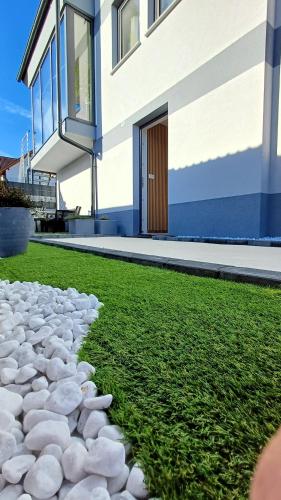 a house with a grassy yard next to a building at Apartmaji STARS in Mavčiče