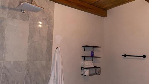 a bathroom with a shower with a towel on a wall at Cabaña Beto’s in Mazamitla