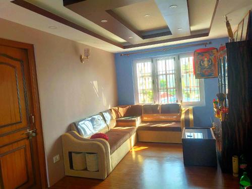 ein Wohnzimmer mit einem Sofa und einem Fenster in der Unterkunft Peace Homestay in Kathmandu