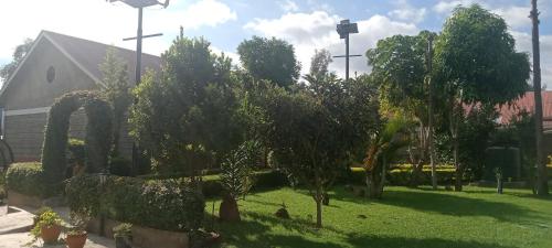 Dole Gardens Naivasha في نيفاشا: حديقة فيها اشجار وشجيرات امام مبنى