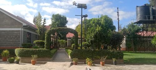 Dole Gardens Naivasha في نيفاشا: حديقة بها شجيرات وأشجار ومبنى
