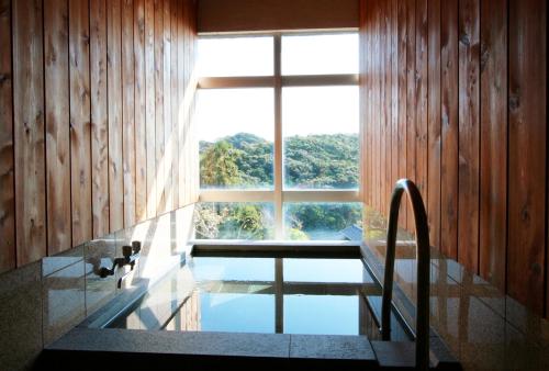 a bathroom with a window and a sink and a tub at 鵜原館 -Ubarakan- in Katsuura
