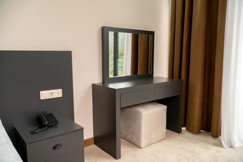 a bedroom with a black vanity with a mirror at Chateau Milisi in Batumi