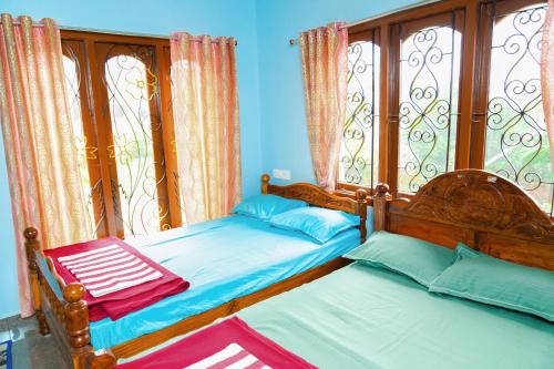 a bedroom with two twin beds and a window at Prabas - Farm house in Puducherry