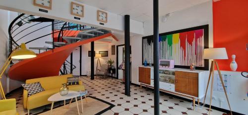 a living room with a yellow couch and a staircase at Hôtel La Croisette & Restaurant Bistrot Gantier in Royan