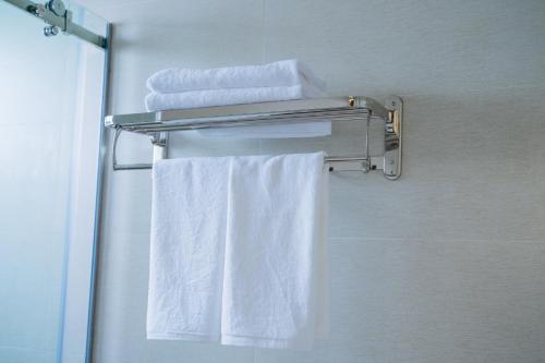 a towel rack with white towels in a bathroom at Khách Sạn A68 in Vung Tau