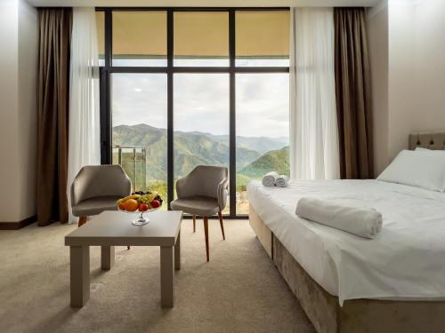 a hotel room with a bed and a large window at Chateau Milisi in Batumi