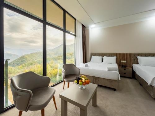 a hotel room with two beds and a chair at Chateau Milisi in Batumi