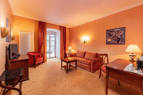 a living room with a couch and a table at Göbels Schlosshotel "Prinz von Hessen" in Friedewald