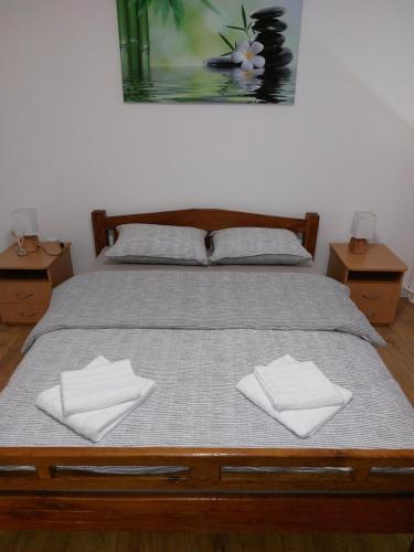 a bed with two white towels on top of it at Apartman Aura Prijedor in Prijedor