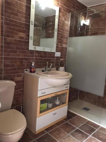 a bathroom with a sink and a toilet and a mirror at El Canchal de Eladia in Valdeverdeja