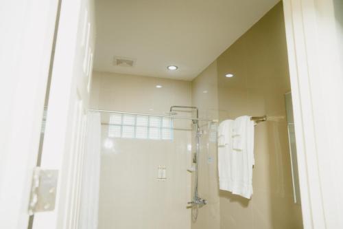 奧斯洛布的住宿－AJ's Place Beach Resort，带淋浴、毛巾和淋浴的浴室
