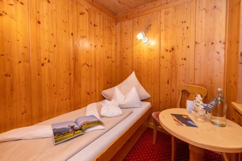 a room with a bed and a table with books at Der Schütthof in Zell am See