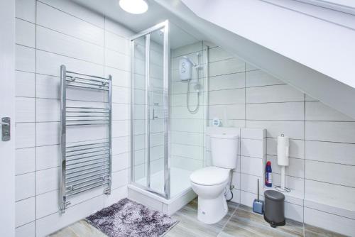 Charming 7 bedroom house sleeps up to 13 guests في رومفورد: حمام مع مرحاض وممشى في الدش