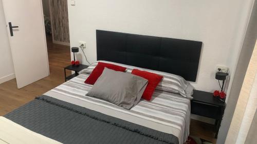 una camera da letto con un grande letto con cuscini rossi di Casa Bia Plus a Elche