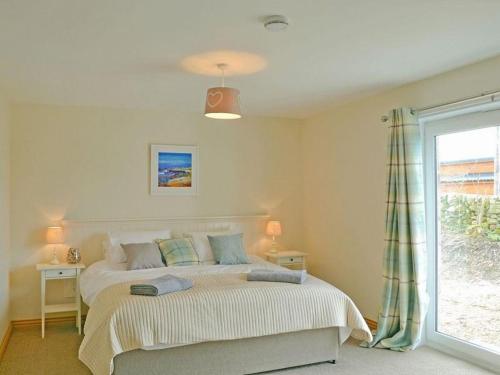 a bedroom with a large bed and a window at Fleet View in Gatehouse of Fleet