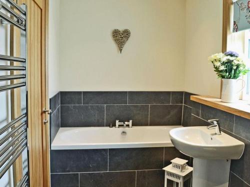 a bathroom with a bath tub and a sink at Fleet View in Gatehouse of Fleet