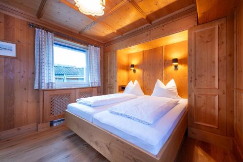 カプルーンにあるChalet Georgの木製の部屋に大型ベッドが備わるベッドルーム1室が備わります。