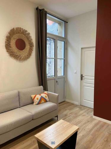 a living room with a couch and a table at Logement entier-Clim-100%équipé-Hypercentre-Balcon in Brive-la-Gaillarde