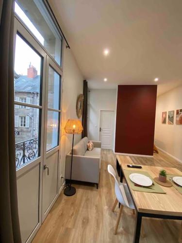 a living room with a table and a couch at Logement entier-Clim-100%équipé-Hypercentre-Balcon in Brive-la-Gaillarde