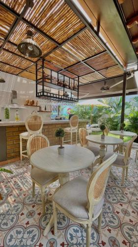 a dining room with tables and chairs and a kitchen at Matisia Hotel Boutique in Guaduas