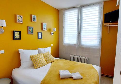 a bedroom with a large bed with two towels on it at Hôtel La Croisette & Restaurant Bistrot Gantier in Royan