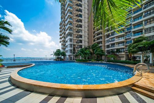 a large swimming pool in front of a building at Seafront Country Garden Danga Bay by Lions Bay in Johor Bahru
