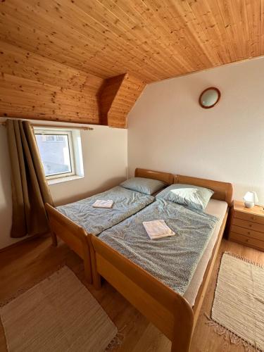 Cama en habitación con techo de madera en Apartment Dehtáře, en Dehtáře