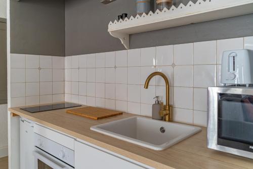 a kitchen with a sink and a microwave at Au cœur de l'Effervescence Terracotta - Une Nuit à Nîmes in Nîmes