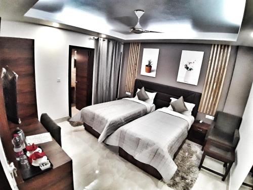 a bedroom with two beds and a chair in it at Airport Hotel Delhi Aerocity, Near Yashobhoomi in New Delhi