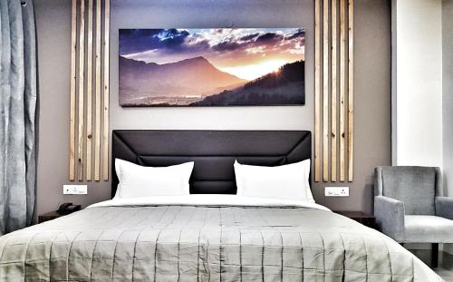 a bedroom with a bed and a painting on the wall at Airport Hotel Delhi Aerocity in New Delhi