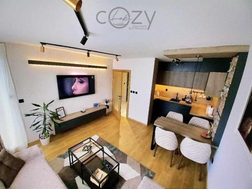 a living room with a couch and a table in a room at Apartman -Cozy Lake- Sarajevo in Lukavica