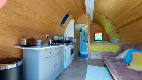 una cocina y sala de estar en una casa pequeña en Robin- Ensuite Glamping Pod, en Truro