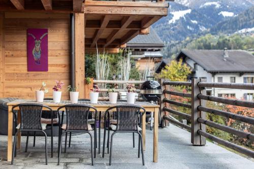 a table and chairs on the deck of a cabin at La Ruinette - Modern 2 Bed, Close To The Lift in Le Châble