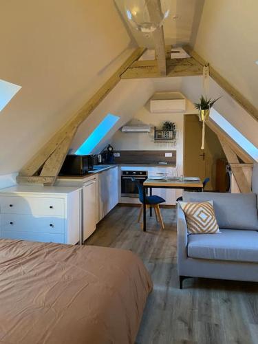 ブリーヴ・ラ・ガイヤルドにあるAppartement chaleureux - Clim réversible - Meublé A-Zのベッド、テーブル、キッチンが備わる客室です。