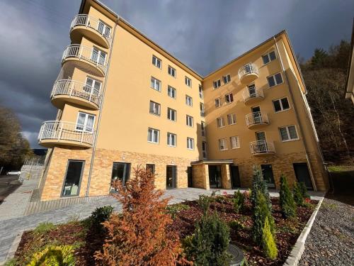 a large yellow building with balconies on it at Apartmán NeKLID in Jáchymov