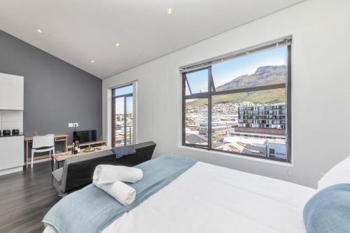 ein Schlafzimmer mit einem Bett und einem großen Fenster in der Unterkunft Mountain View Apartment at Woodstock Quarter in Kapstadt
