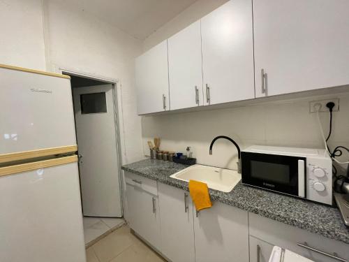 a kitchen with a sink and a microwave at עלמה in Tel Aviv