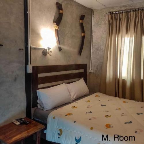 1 dormitorio con cama, mesa y cuernos en la pared en WildHomeบ้านพัก ปากช่อง-เขาใหญ่ en Pak Chong