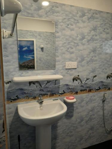 a bathroom with a sink and a mirror at Royal Villa in Ahangama