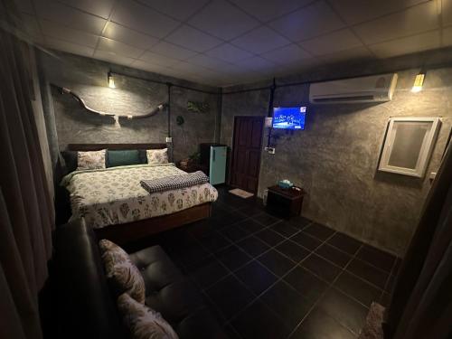 1 dormitorio con 1 cama y TV. en WildHomeบ้านพัก ปากช่อง-เขาใหญ่ en Pak Chong
