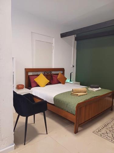ein Schlafzimmer mit einem Bett und einem Stuhl darin in der Unterkunft סטודיו איתמר in Tel Aviv