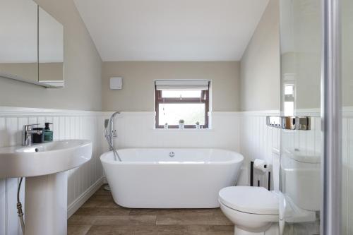 a white bathroom with a tub and a toilet at Home in Llanberis in Llanberis