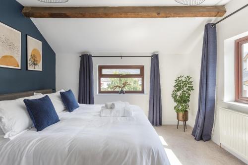 a bedroom with a large white bed with blue pillows at Home in Llanberis in Llanberis