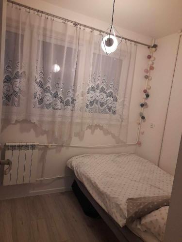 a small bedroom with a bed and a curtain at Mieszkanie na Przymorzu in Gdańsk