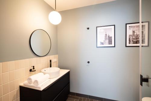 a bathroom with a sink and a mirror at B85 Suites in Warsaw